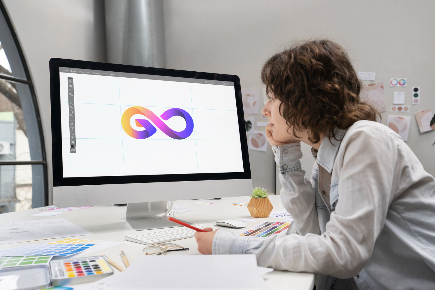 Diseñadora trabajando en el logotipo de una marca en la pantalla de su ordenador